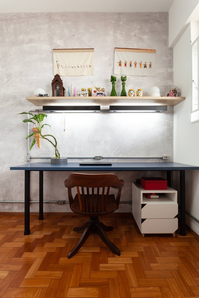 Estilo industrial e móveis retrô marcam apê de 75 m² em Belo Horizonte. Projeto de Mutabile Arquitetura. NA foto, quarto com home office com mesa azul, prateleira e cimento queimado.