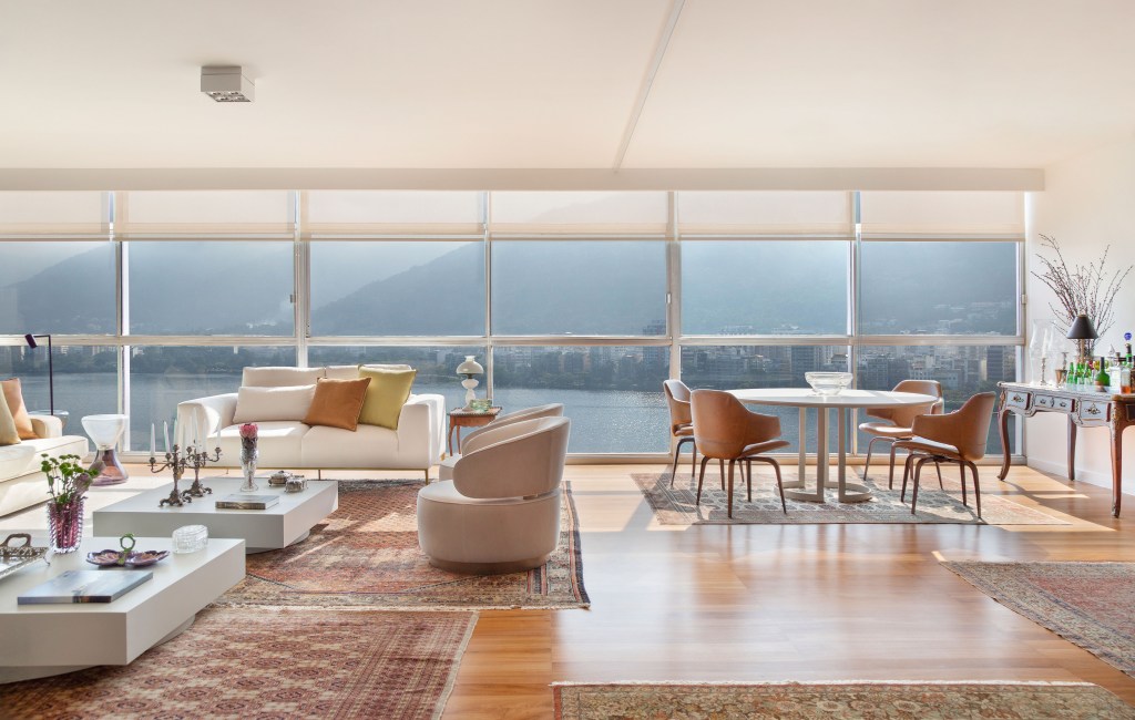 Projeto de Ricardo Melo e Rodrigo Passos. Na foto, sala de estar e jantar integradas com piso de madeira janela com vista.