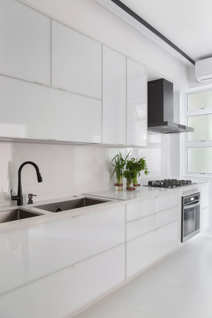 Projeto de Ricardo Melo e Rodrigo Passos. Na foto, cozinha branca com armários branco laqueados.