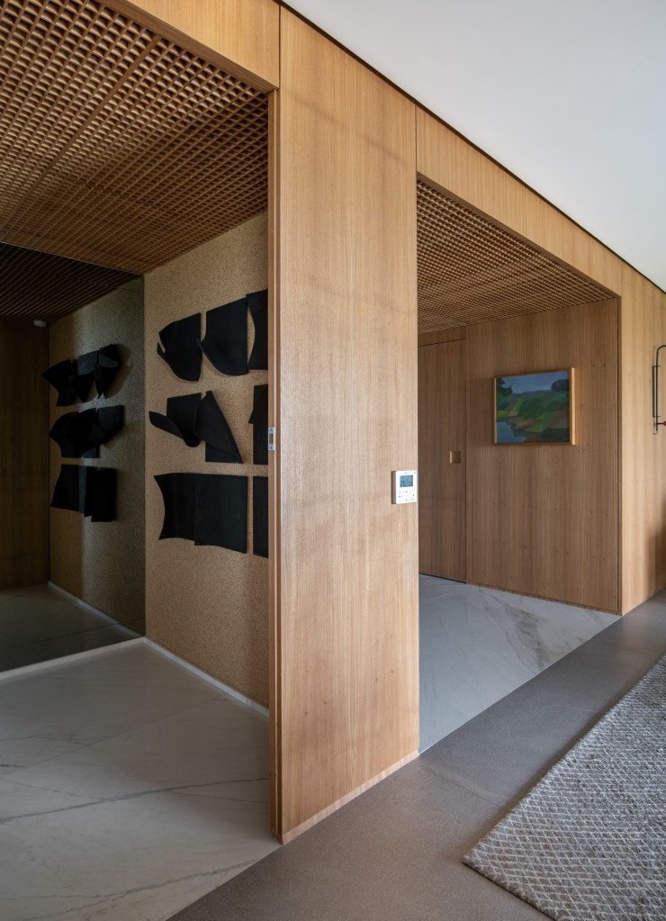 Forro iluminado de muxarabi cria sensação de luz natural em apê de 278 m². Projeto de Cris Furlan. Na foto, hall de entrada com teto de muxarabi e esculturas,