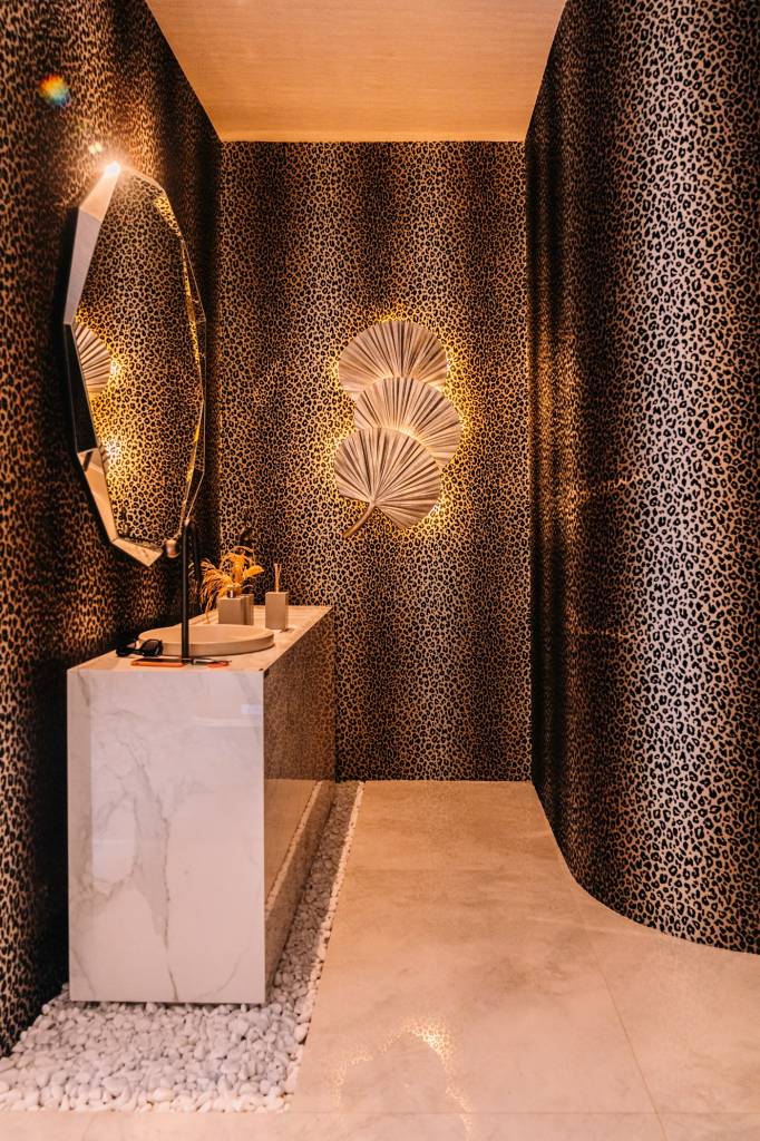 Loft sofisticado ganha lavabo com parede animal print e paredes curvas. Projeto de Daniele Franco para a CASACOR Brasília 2023. Na foto, lavabo com parede de animal print.