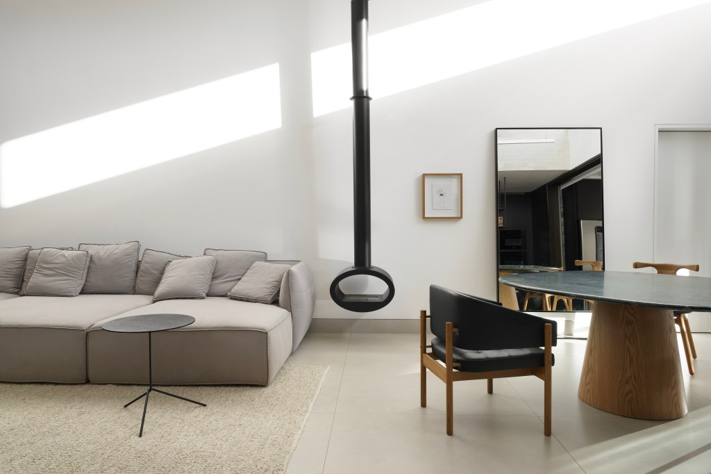 Minimalismo e décor contemporâneo marcam casa térrea de 273m². Projeto de Piacesi Arquitetos. Na foto, sala com paleta clara e lareira preta.