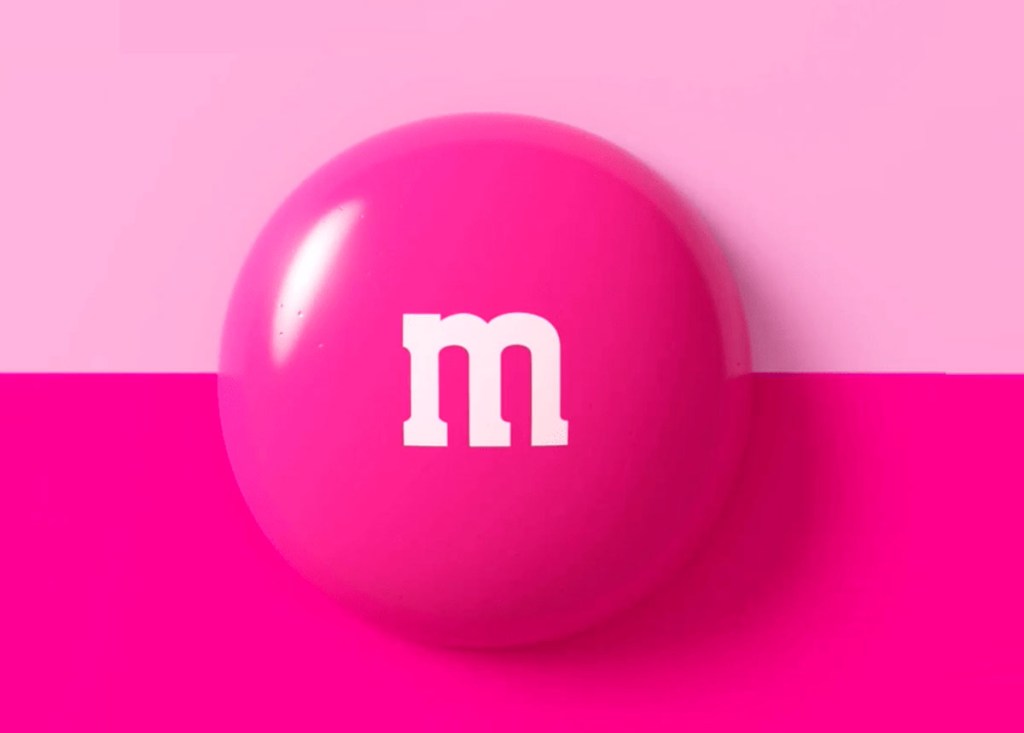 M&M’S traz chocolate rosa em mês da conscientização sobre o câncer de mama. Na foto, M&M rosa em fundo rosa.