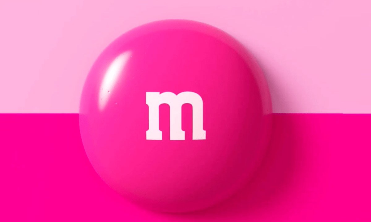 M&M’S traz chocolate rosa em mês da conscientização sobre o câncer de mama. Na foto, M&M rosa em fundo rosa.