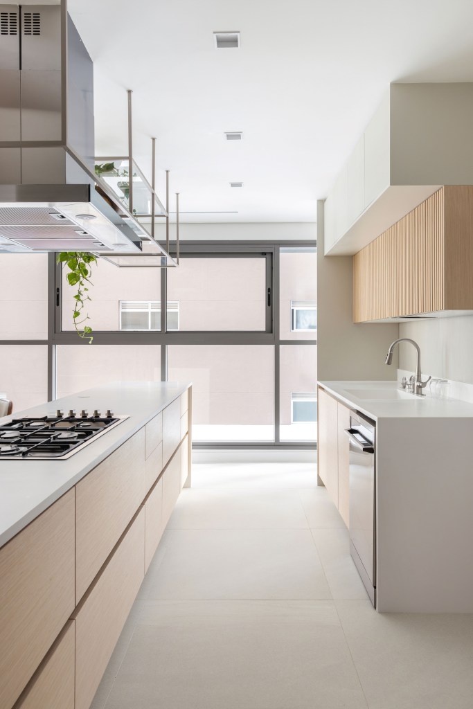Projeto de Paula Muller. Na foto, cozinha minimalista com marcenaria branca.