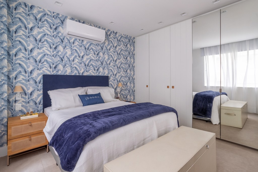 Papel de parede floral e toques de azul dão ar cozy à este apê de 200m². Projeto de Ana Cano. Na foto, quarto de casal com papel de parede azul.