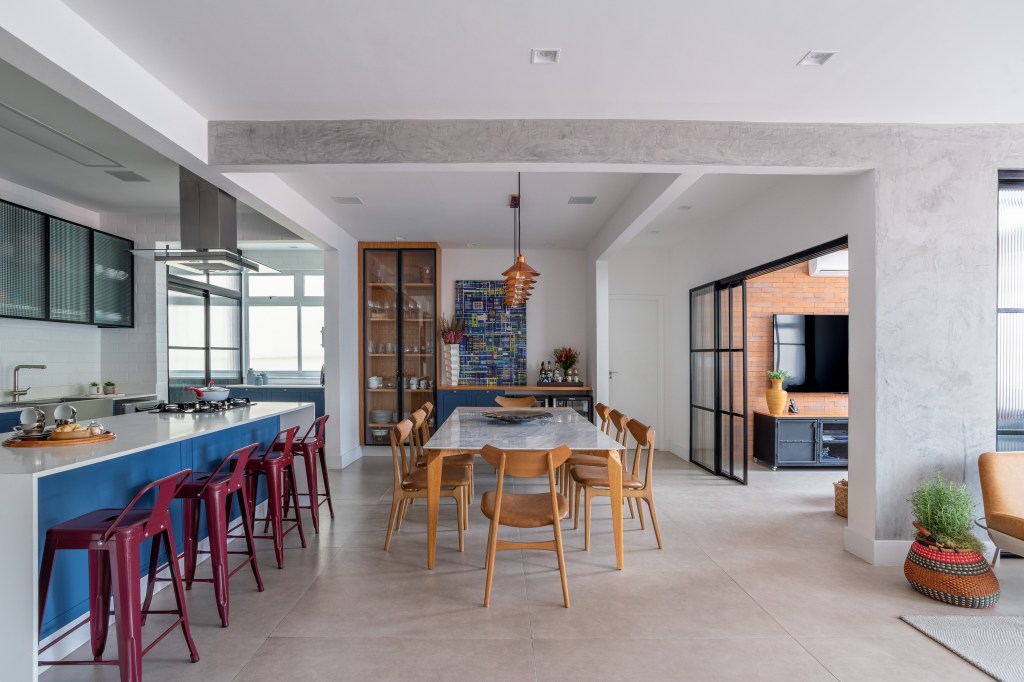 Papel de parede floral e toques de azul dão ar cozy à este apê de 200m². Projeto de Ana Cano. Na foto, sala de jantar integrada com cozinha.
