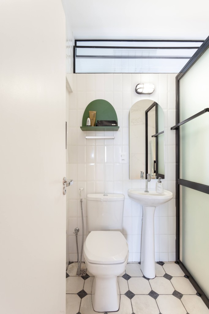 Cada parede sala é de uma cor neste apê de 80 m² com dois home offices. Projeto de Mutabile Arquitetura. Na foto, banheiro com piso preto e branco.