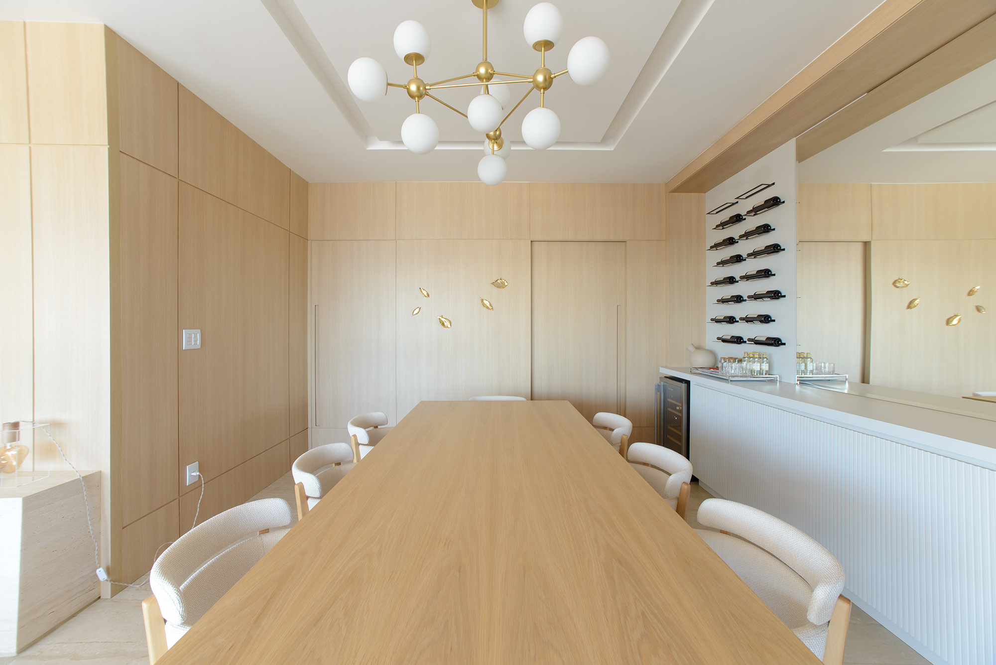 Paredes de madeira e tons de laranja compõem o décor deste apê de 138 m². Projeto de Letícia Nannetti. Na foto, sala de jantar com adega na parede, e parede de madeira.