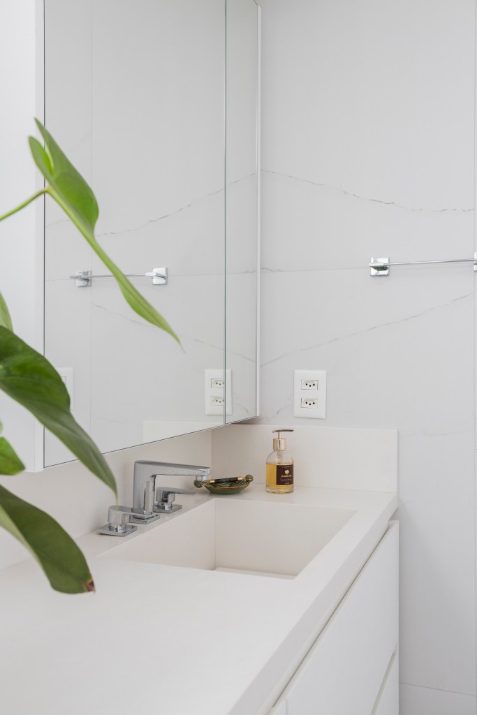 Projeto de Tatu Arquitetura. Na foto, banheiro com bancada branca e cuba esculpida.