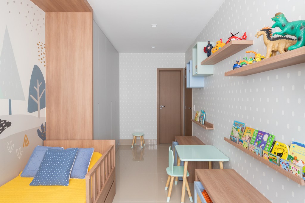Rede na sala e penteadeira na mesa de trabalho marcam apê de 140 m². Projeto de Morada 3112. Na foto, quarto infantil com biblioteca e papel de parede estampado.
