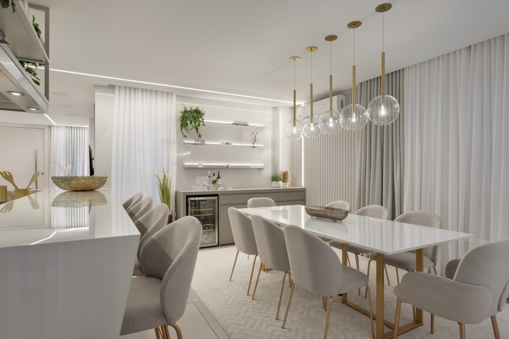 Sem muito quebra-quebra, casa de 205 m² ganha décor clássico e sofisticado. Projeto Carol Dallagrana. Na foto. sala de jantar com mesa branca, pendentes e adega.