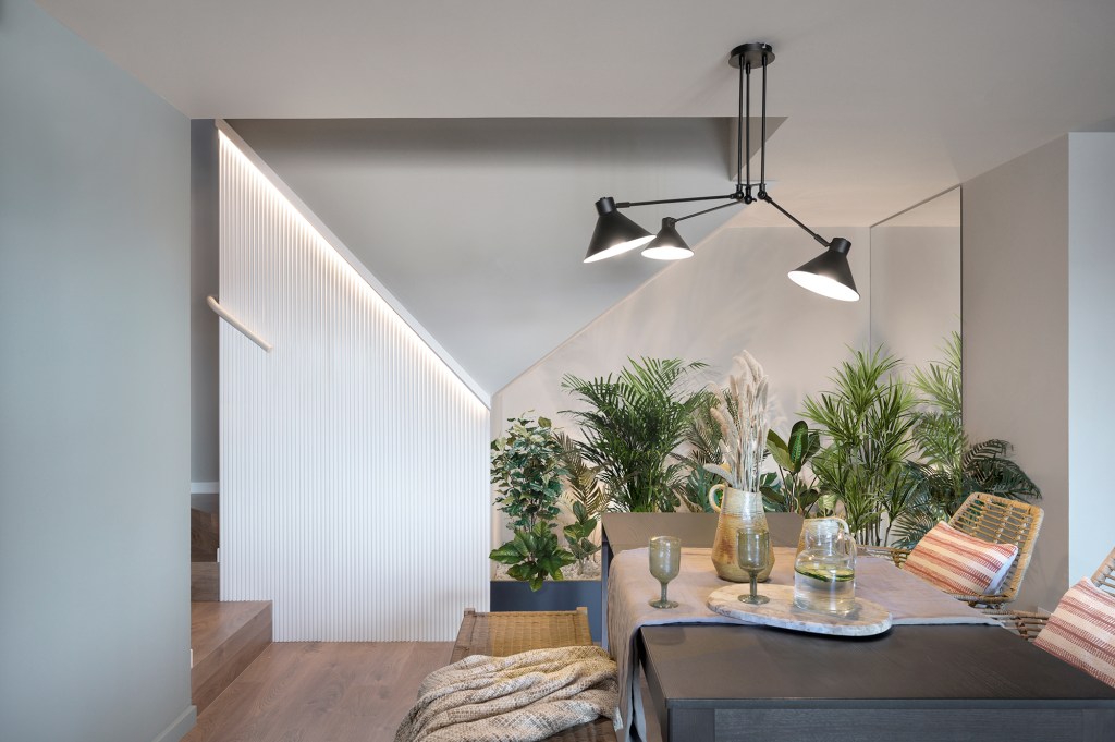 Terraço de dúplex de 192 m² em Barcelona é uma verdadeira sala nas alturas. Projeto de Egue y Seta. NA foto, sala de jantar, vasos e plantas e escada.