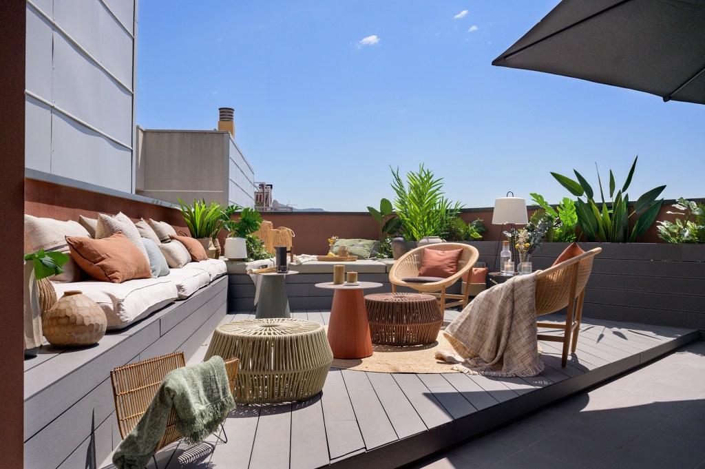 Terraço de dúplex de 192 m² em Barcelona é uma verdadeira sala nas alturas. Projeto de Egue y Seta. Na foto, terraço com estar com poltrona e plantas.