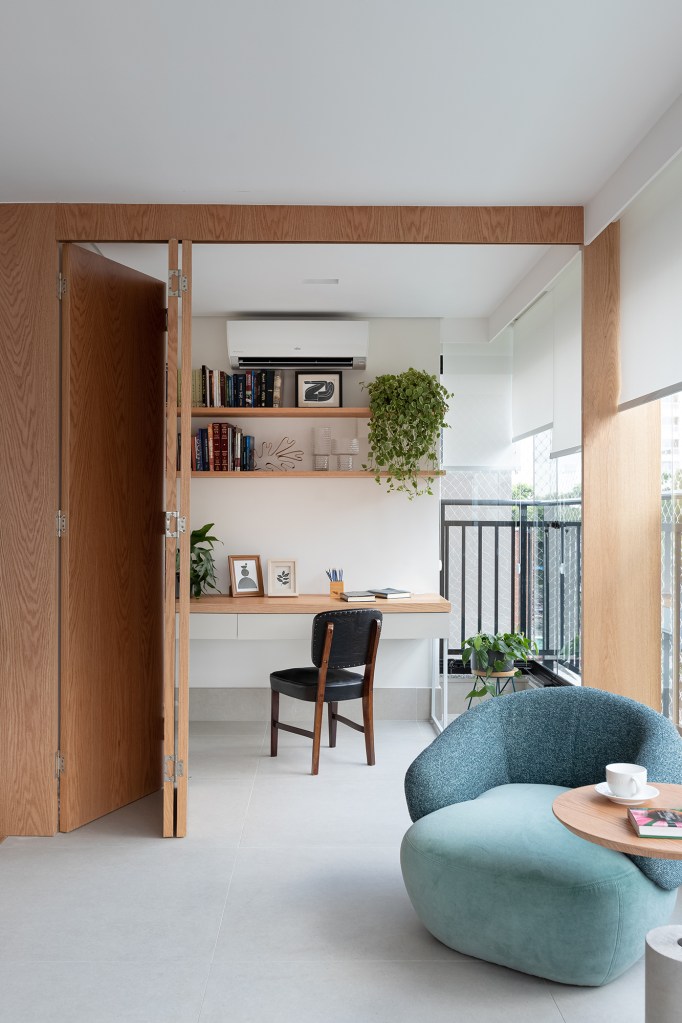 Apartamento de 147 m² ganha ambientes integrados e repletos de luz natural. Projeto de Estúdio Maré. Na foto, home office escondido por paineis na varanda.