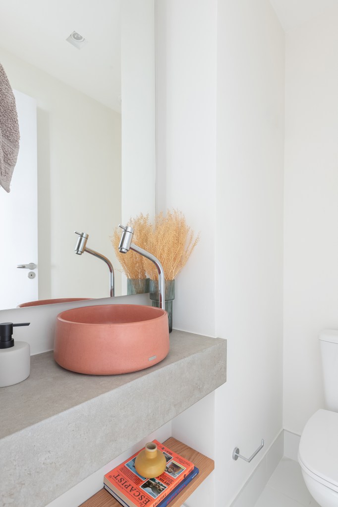 Apartamento de 147 m² ganha ambientes integrados e repletos de luz natural. Projeto de Estúdio Maré. Na foto, lavabo com cuba rosa.