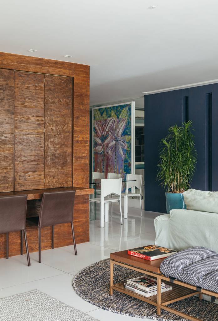 Apê de Ciro Bottini tem paleta Art Deco Navy com tons azuis e dourados. Projeto de Casa Cururu. Na foto, sala com piso de porcelanato.