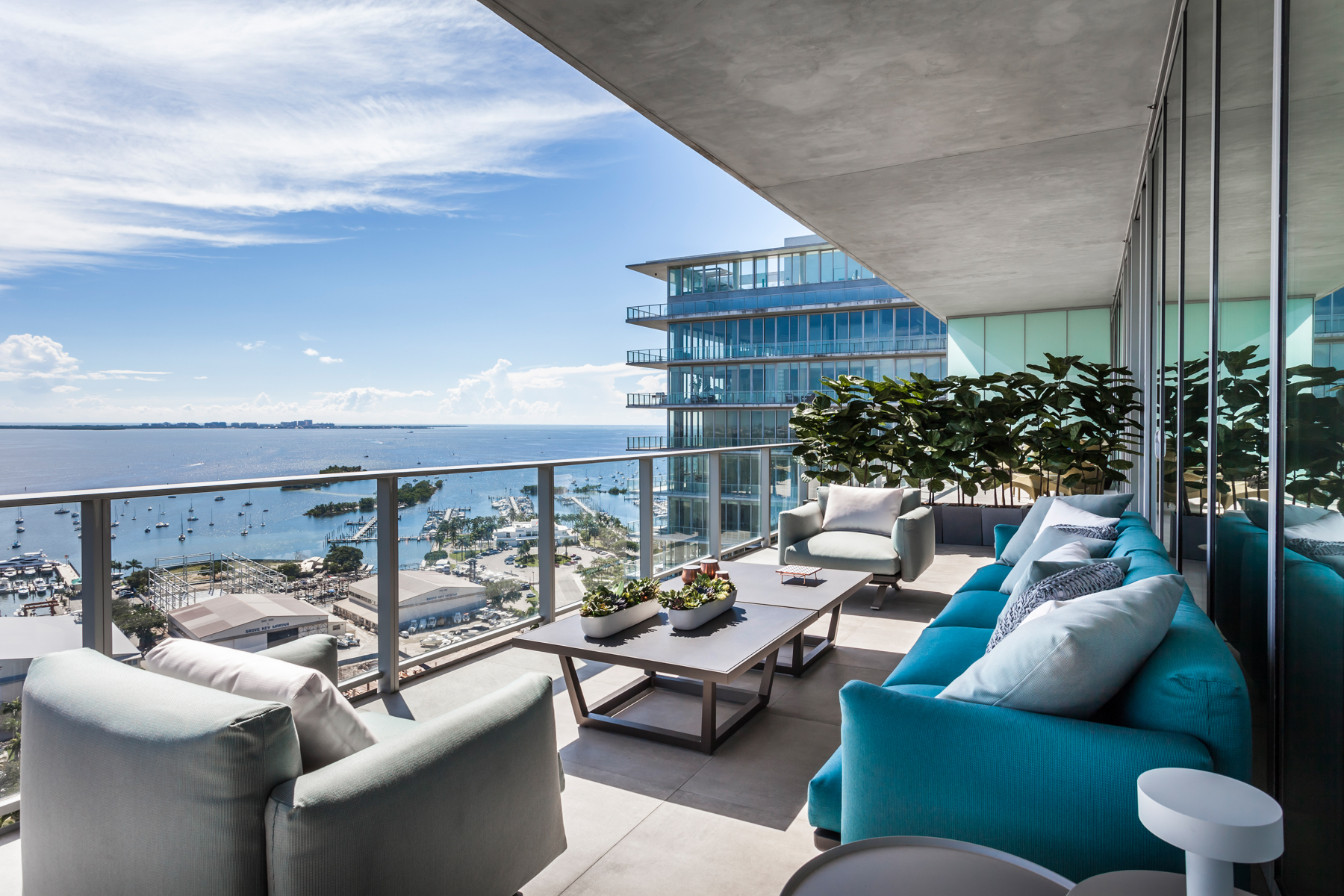 Apê de 500 m² com vista para o mar de Miami tem mix de materiais no décor. Projeto de Andrea Chicharo. Na foto, varanda com vista para o mar e sofás.