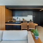 Apê de 90 m² tem cozinha com marcenaria preta e cuba triangular no lavabo