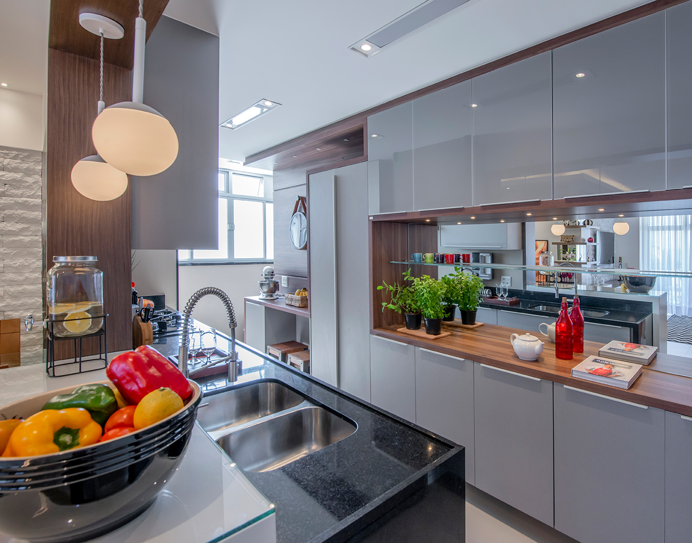 Apê de 90 m² ganha layout funcional após troca de paredes de lugar. Projeto de Campos & Olivetti Arquitetura. Na foto, cozinha corredor com parece de espelho e passa prato.