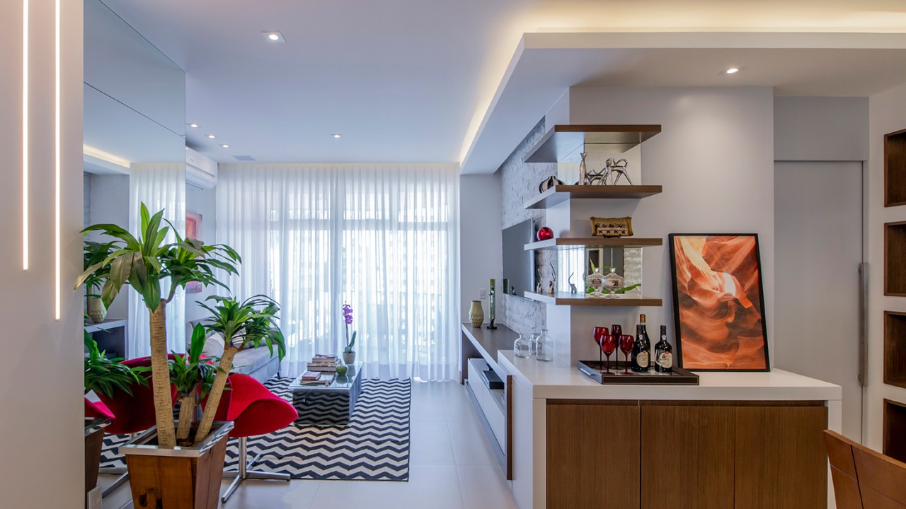 Apê de 90 m² ganha layout funcional após troca de paredes de lugar. Projeto de Campos & Olivetti Arquitetura. Na foto, sala de estar e jantar com marcenaria planejada e tapete chevron.
