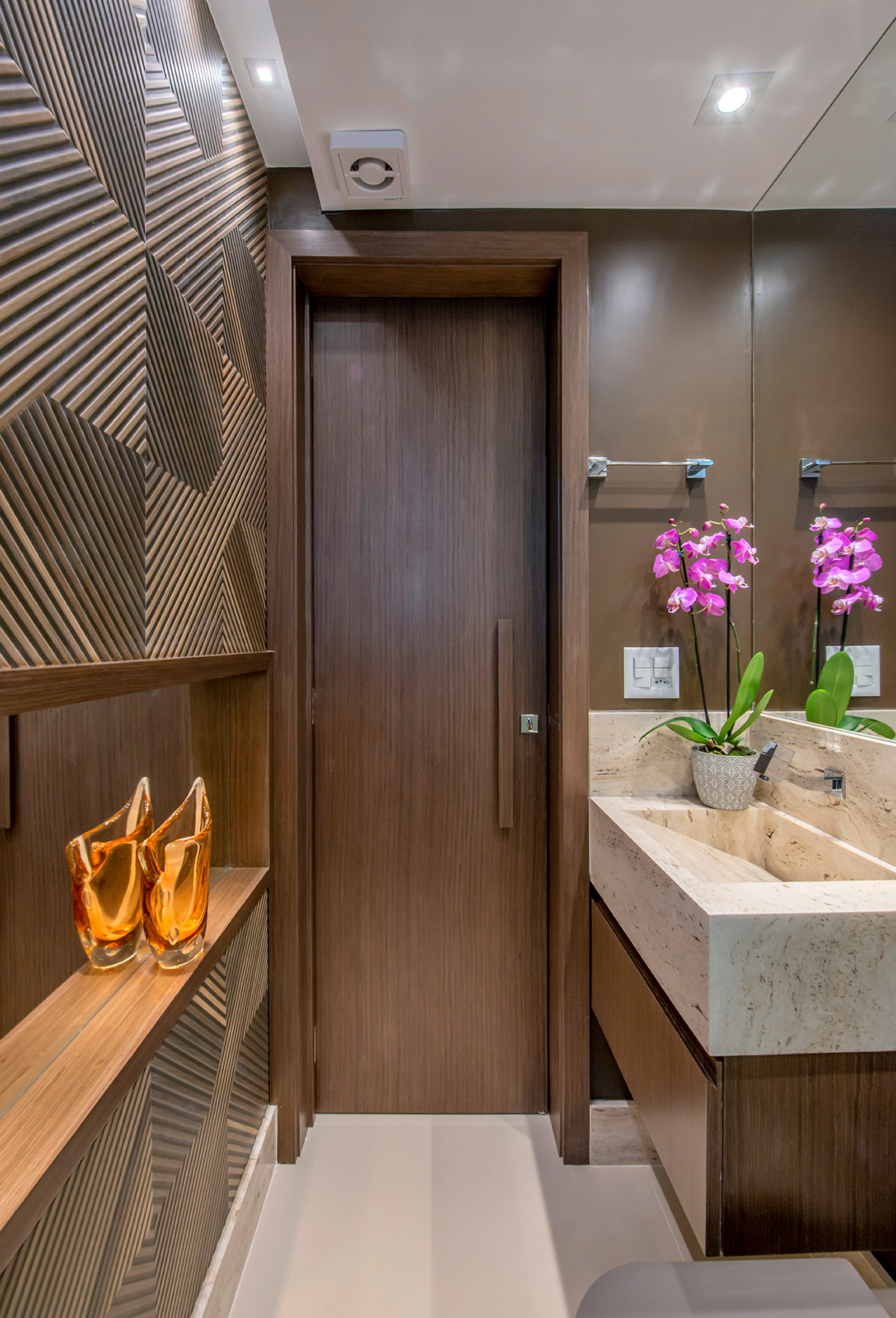 Apê de 90 m² ganha layout funcional após troca de paredes de lugar. Projeto de Campos & Olivetti Arquitetura. Na foto, lavabo com painel de madeira.