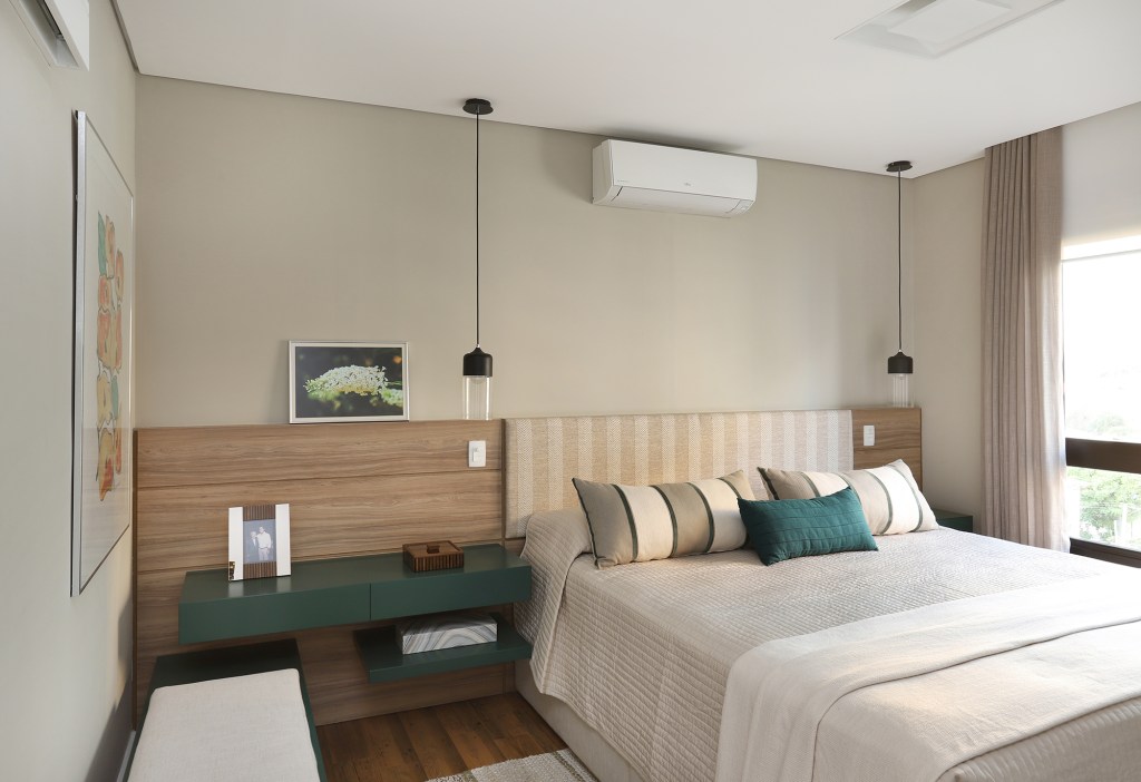 Apê descolado de 120 m² tem décor inspirado nos quadros do cliente. Projeto Inovando Arquitetura. Na foto, quarto de casal com cabeceira de madeira e mesa verde.