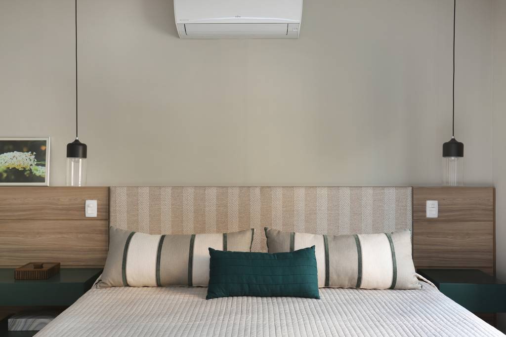 Apê descolado de 120 m² tem décor inspirado nos quadros do cliente. Projeto Inovando Arquitetura. Na foto, quarto de casal com cabeceira de madeira e mesa verde.