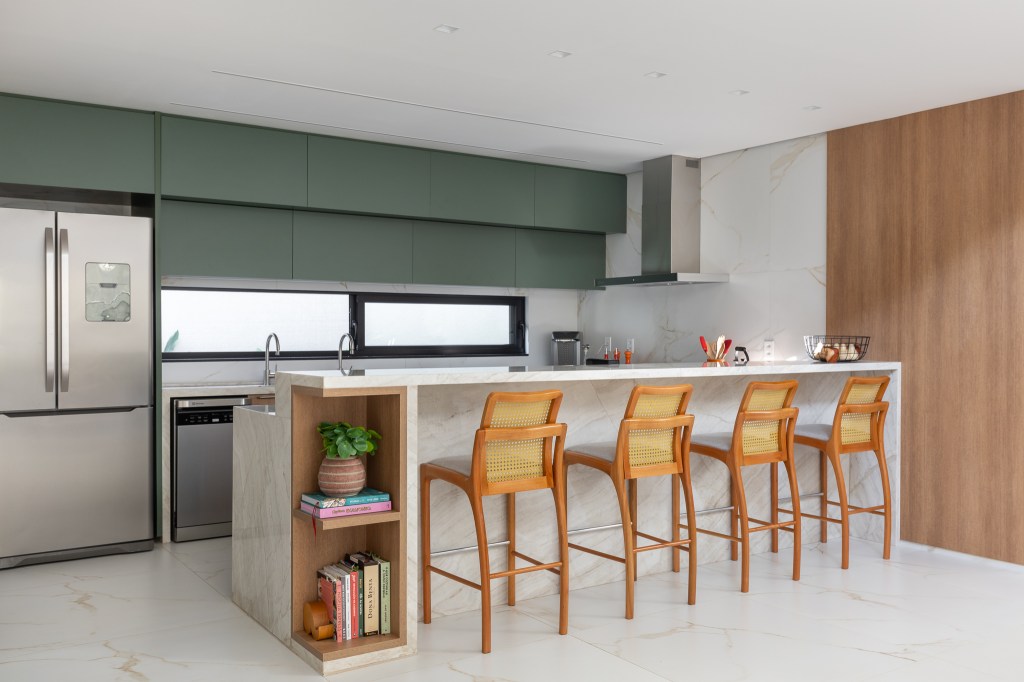 Casa com arquitetura clean foi pensada para as festas da família. Projeto de Visivo Arquitetura. Na foto, cozinha com parede verde e cuba dupla.