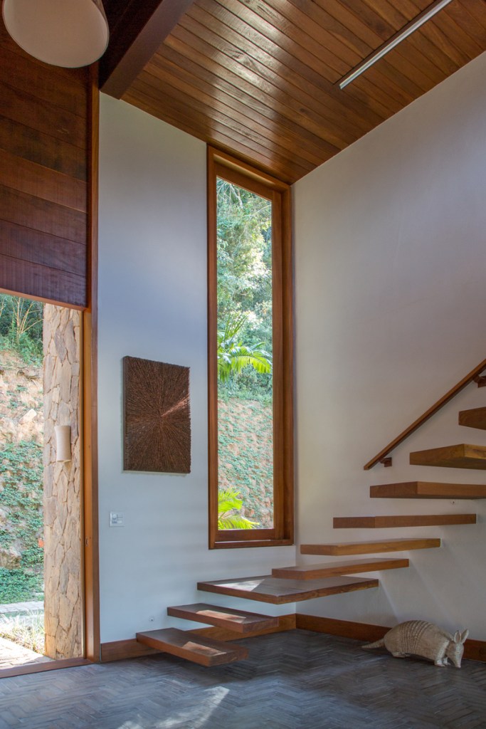 Casa na serra imersa na natureza possui vista espetacular para montanhas. Projeto de Andrea Chicharo. Na foto, escada flutuante com vista para o jardim.