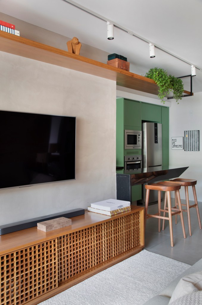 Cozinha com armário verde laqueado e bancada de granito é destaque em apê. Projeto de Ao Quadrado Arquitetura. Na foto,