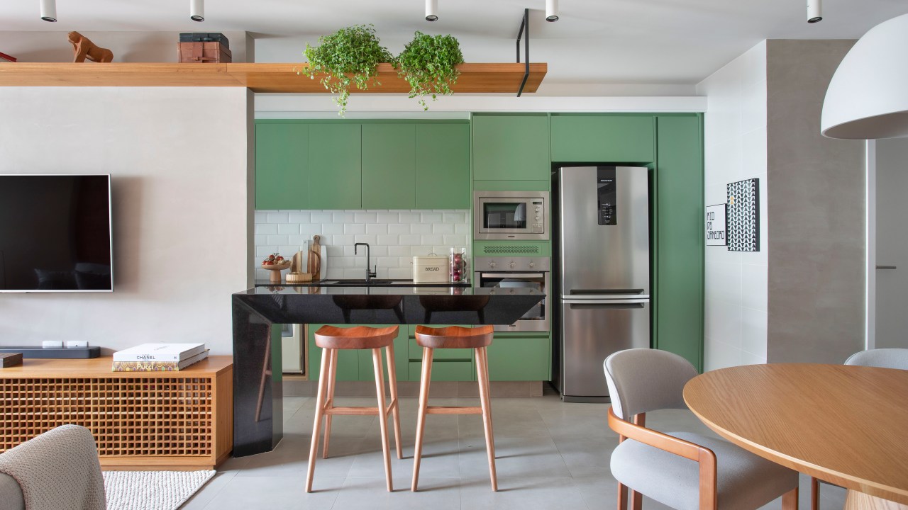 Cozinha com armário verde laqueado e bancada de granito é destaque em apê. Projeto de Ao Quadrado Arquitetura. Na foto, cozinha com marcenaria verde.
