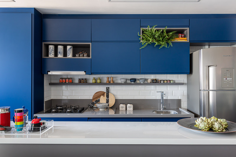 Confira 4 ideias de cores para marcenaria de cozinhas para te inspirar. Projeto de Natalia Salla. Na foto, cozinha com marcenaria azul e bancada branca.
