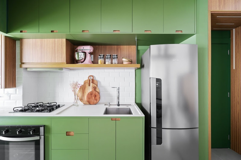 Confira 4 ideias de cores para marcenaria de cozinhas para te inspirar. Projeto de Natalia Salla. Na foto, cozinha com marcenaria verde e bancada branca.