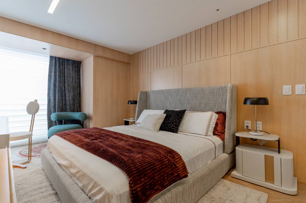 Móveis coloridos e mix de revestimentos dão o tom do décor neste apê. Projeto de Romário Rodrigues. Na foto, quarto com cabeceira cinza e parede amadeirada.