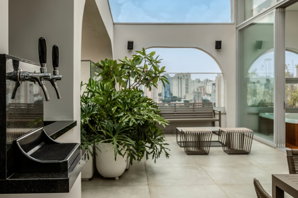 Reforma transforma apartamento de 362 m² em refúgio urbano minimalista. Projeto Inovando Arquitetura. Na foto, varanda com chopeira e poltronas.