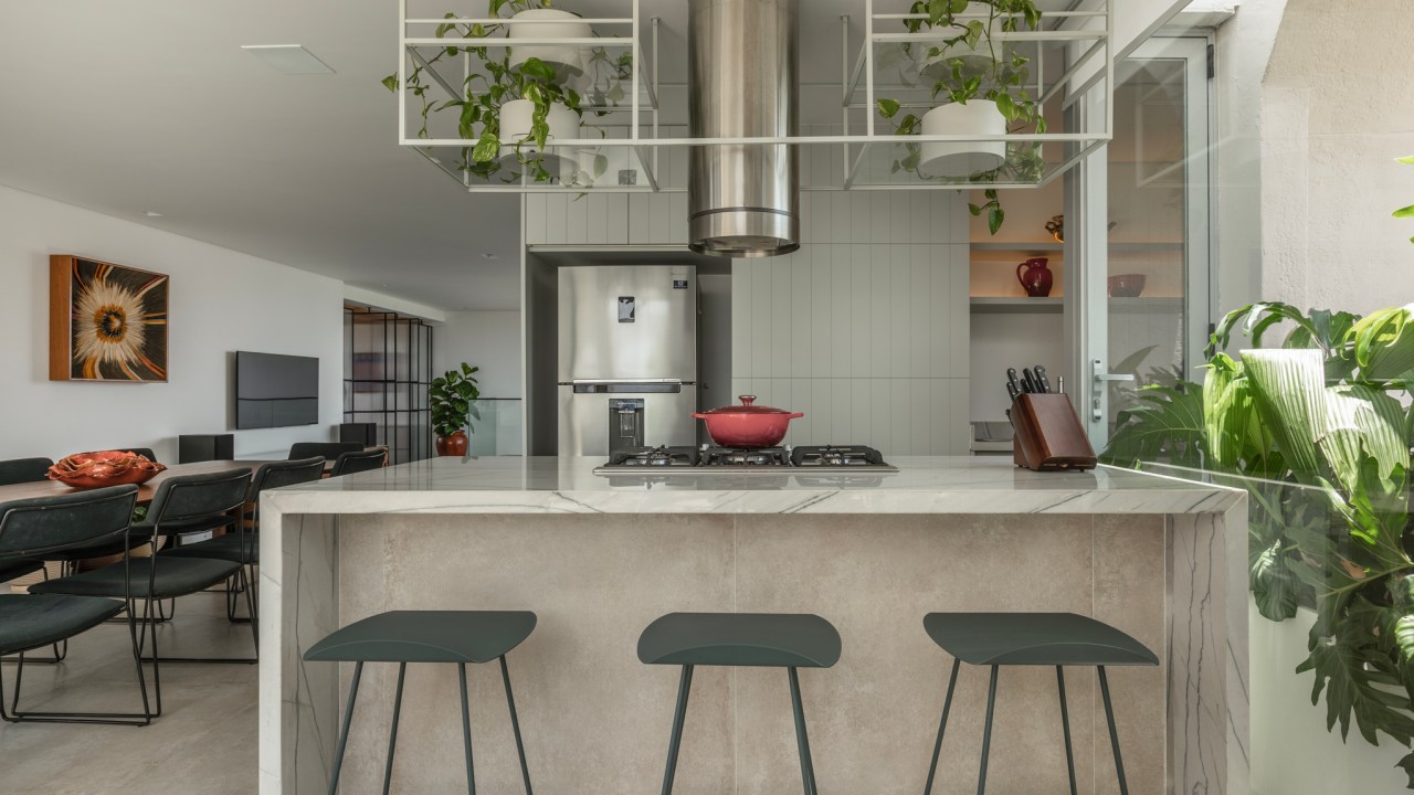 Reforma transforma apartamento de 362 m² em refúgio urbano minimalista. Projeto Inovando Arquitetura. Na foto, espaço gourmet com cozinha com ilha, prateleira suspensa e sala de jantar.