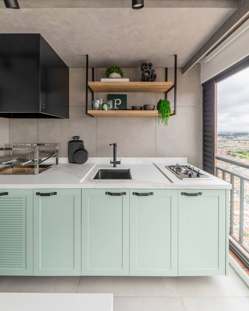 Sem quebra-quebra, apê de 150 m² ganha integração e décor industrial. Projeto de BMA Arquitetura, Na foto, varanda com cozinha gourmet verde.