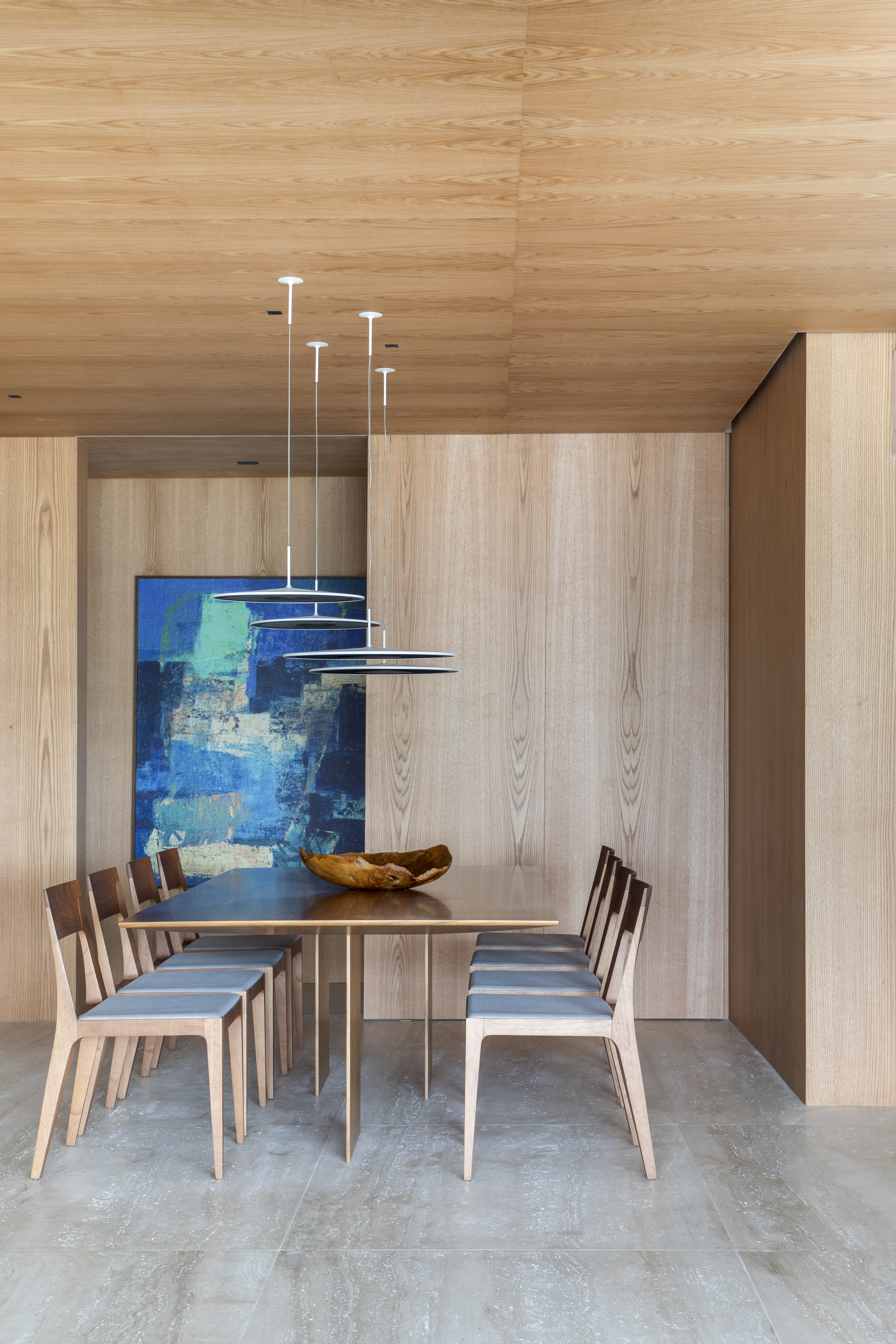 Varanda gourmet espaçosa com ilha travertino natural é destaque em apê. Projeto de Up3 Arquitetura. Na foto, sala de jantar com pórtico de madeira.