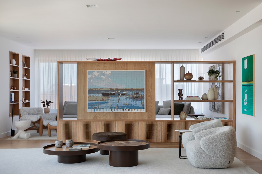 Com vista para o mar, apê de 302 m² foi pensado para o futuro da família. Projeto Sabugosa Arquitetura. Na foto, sala co mvista para o mar e estante divisória.