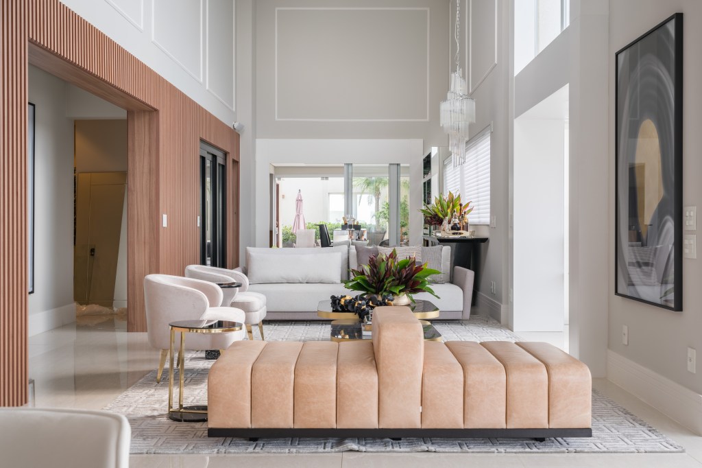 Ambientes Peach Fuzz. Projeto de Spaço Interior. Na foto, sala de estar com pé-direito alto e sofá ilha na cor peach fuzz.