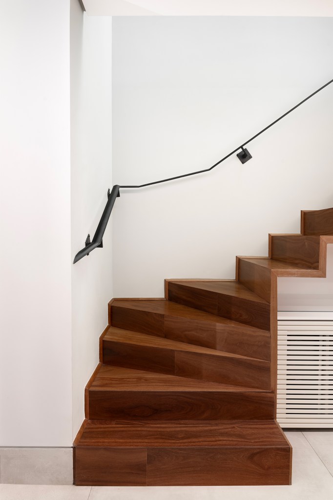 Apartamento de 160 m² em Belo Horizonte ganha décor minimalista e elegante. Projeto de Lucas Lage Arquitetura. Na foto, escada com degraus de madeira e corrimão minimalista.