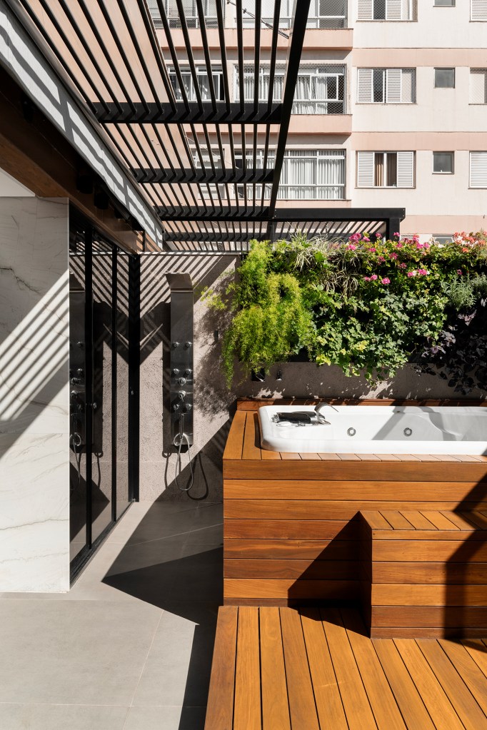Apartamento de 160 m² em Belo Horizonte ganha décor minimalista e elegante. Projeto de Lucas Lage Arquitetura. Na foto, varanda com hidromassagem, deque e poltrona.