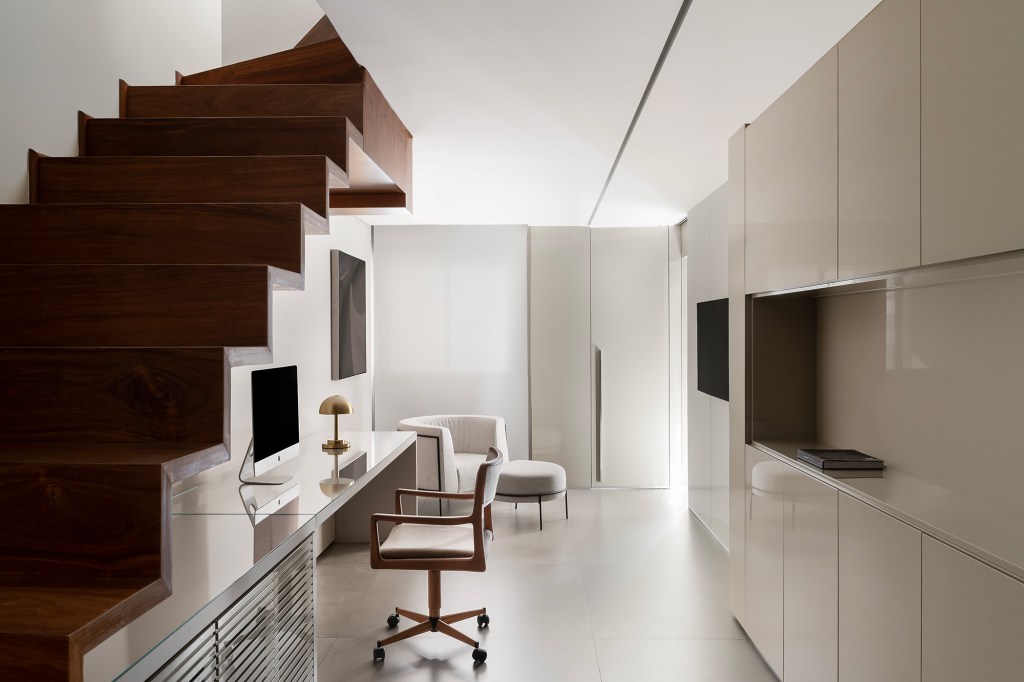 Apartamento de 160 m² em Belo Horizonte ganha décor minimalista e elegante. Projeto de Lucas Lage Arquitetura. Na foto, home office embaixo da escada.