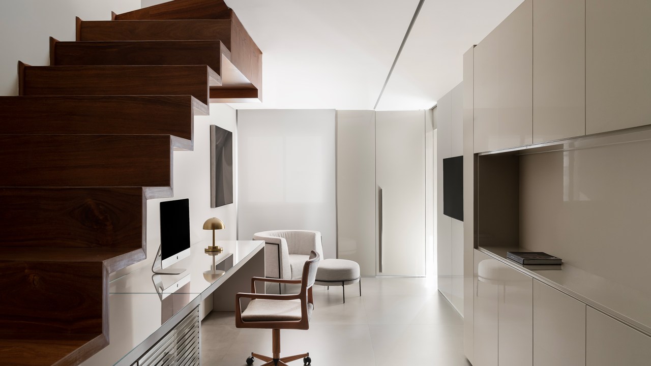 Apartamento de 160 m² em Belo Horizonte ganha décor minimalista e elegante. Projeto de Lucas Lage Arquitetura. Na foto, home office embaixo da escada.