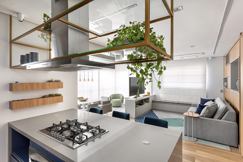 Apê de 102 m² tem Cozinha azul, quarto montessoriano e dois home offices. Projeto de Adriana Diegues. Na foto, cozinha integrada com a sala, prateleira suspensa e sala de TV.