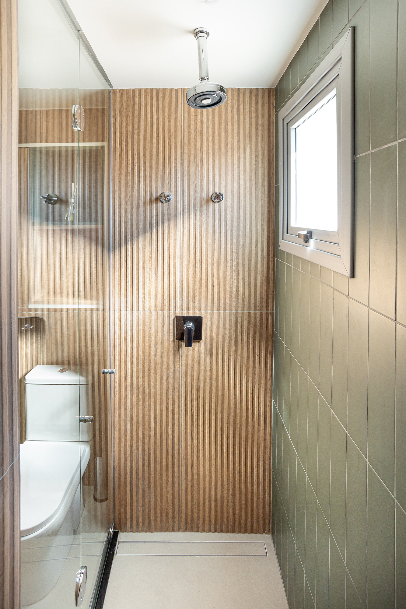 Apê de 36 m² tem lavanderia, home office e banheiro com chuveiro duplo. Projeto Loft 7 Arquitetura. Na foto, banheiro com ripado na parede.