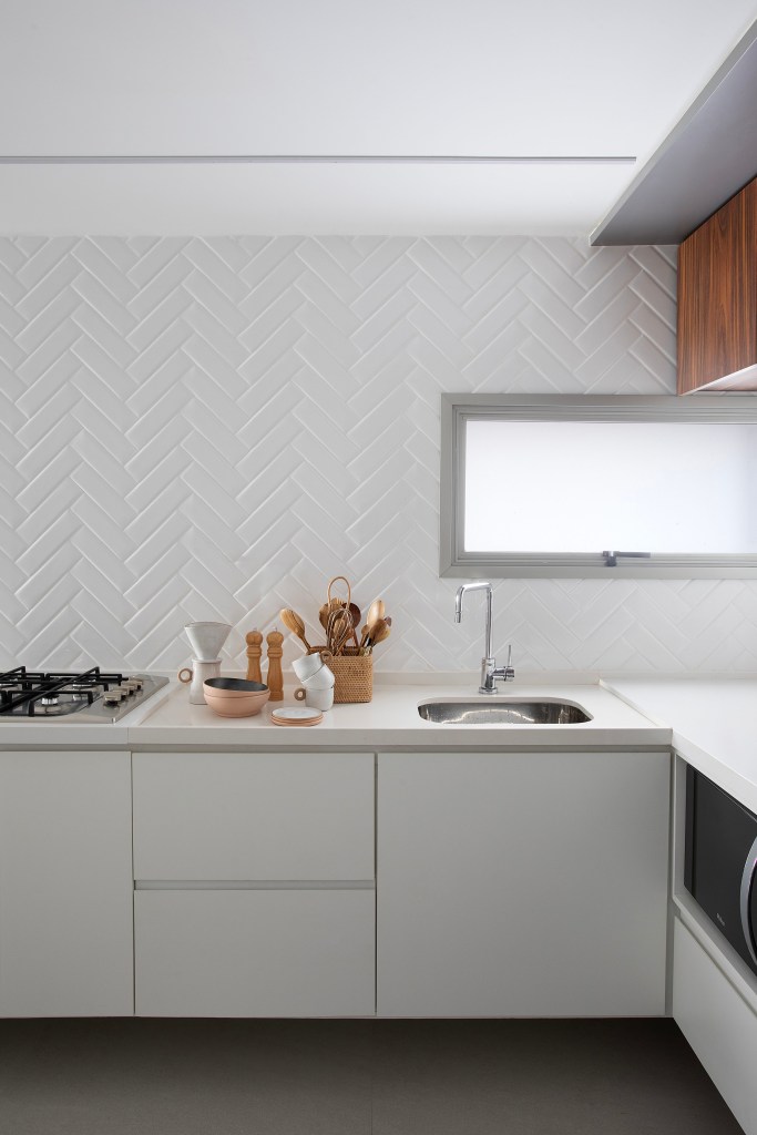 Apê de 75m² recebe décor minimalista em reforma de apenas 3 meses. Projeto de Roby Macedo. Na foto, cozinha minimalista com marcenaria branca.