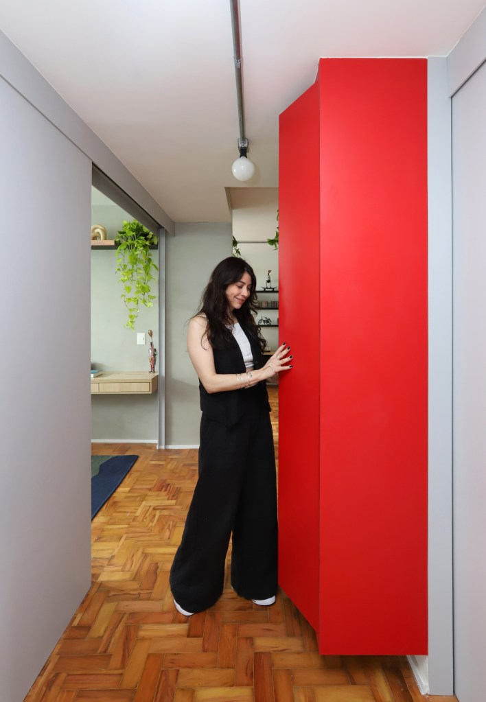 Apê de 90m² tem cozinha rosa, armário vermelho e guarda-roupa azul. Projeto de Studio 92 Arquitetura. Na foto, armário vermelho em corredor.