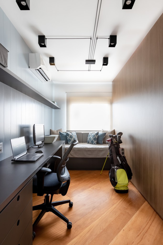 Painel e rack de TV separam living de home office em apê de 75m². Projeto de ISE Arquitetura. Na foto, quarto de hóspedes com home office, bancada.